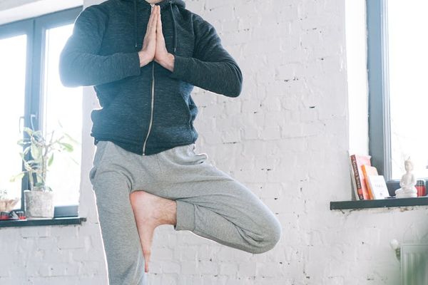 A person in a calm, focused state during a light exercise routine indoors.